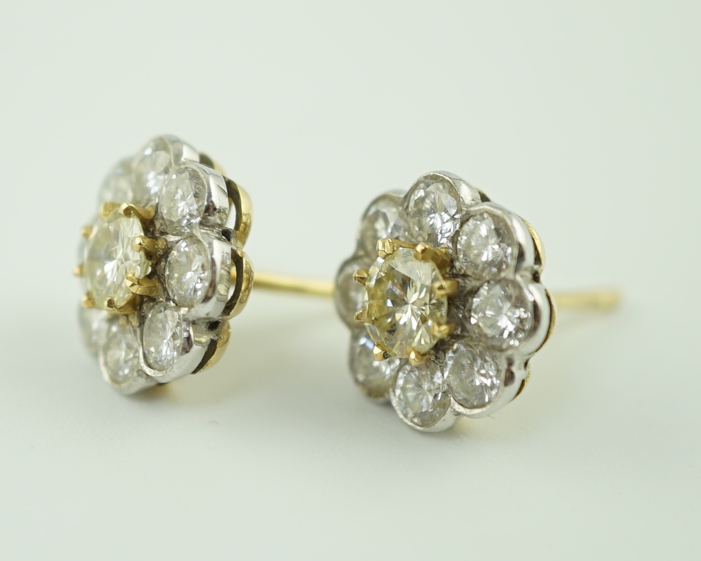 A pair of gold and nine stone diamond cluster set flower head ear studs